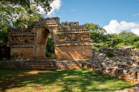 Ancient stone archway stands tall amidst greenery