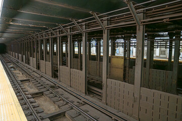 Fototapeta premium Subway tracks extend through an underground steel framework in New York City. The metro tunnel architecture highlights urban transportation infrastructure in Manhattan.