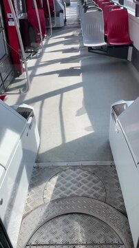 POV first person view inside a modern tram on a sunny day, approaching a stop after pressing the exit button, capturing everyday urban transit. Vertical video taken on mobile device as UGC.