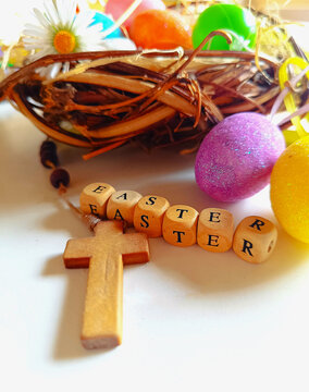 Easter wooden cross with colorful eggs on bright background Easter resurrection religious theme