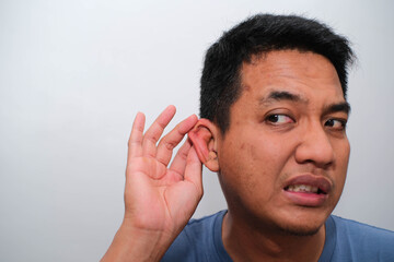 Obraz premium A close-up shot captures a person's ear with a red, swollen area, possibly indicating a skin irritation or infection, as fingers gently touch the lobe.