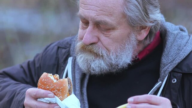 City Life Rhythms - Senior Man eating fast food  on Busy Street