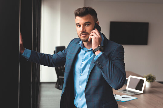 Portrait of a businessman in the office with phone