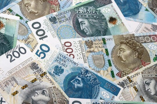 Polish zloty money bills pile on table. Poland banknotes of PLN currency close up.