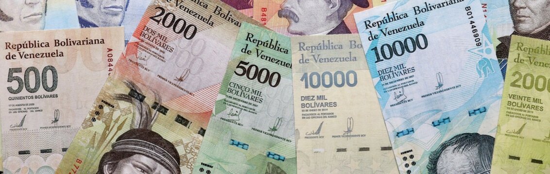 Venezuelan bolivar money bills pile on table. Venezuela banknotes of VES currency close up.