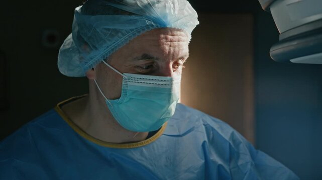 Close up of Caucasian surgeon performing surgical procedure and having small talk with colleague