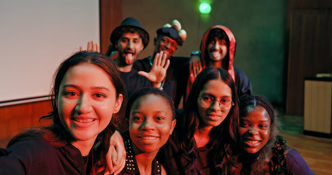 Indian young adult gen z male man female look camera take selfie photos have fun joy hall stage place. Happy teen girl boy group team staring cam do funny pose record video spend day enjoy break time