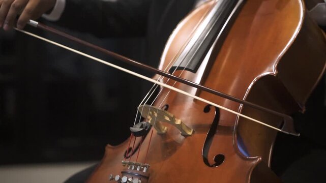 Close up of Musician Playing Cello with Bow in Orchestral Performance