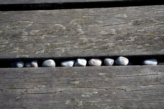 Galets coinc&eacute;s entre des planches sur la plage