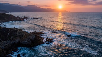 Naklejka premium Coastal Sunset Over Rocky Shoreline with Ocean Waves breaking