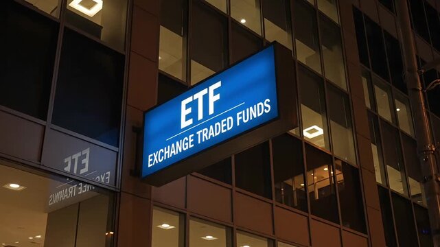 Illuminated etf exchange traded funds sign on modern building exterior at night
