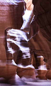View of sunlight dancing on the smooth, sculpted sandstone walls, creating a mesmerizing play of light and shadow in the canyon, Page, Arizona, United States.