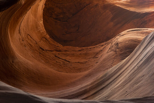 View of swirling sandstone walls carved by time and nature's artistry create a mesmerizing dance of light and shadow in Antelope Canyon, Page, Arizona, United States.
