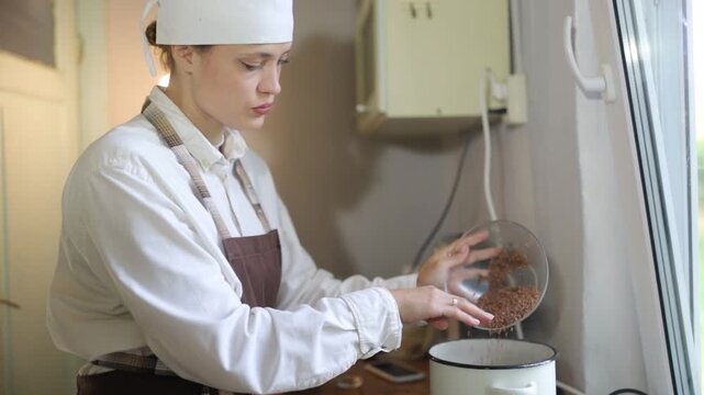 A female chef cooks in the kitchen during the day