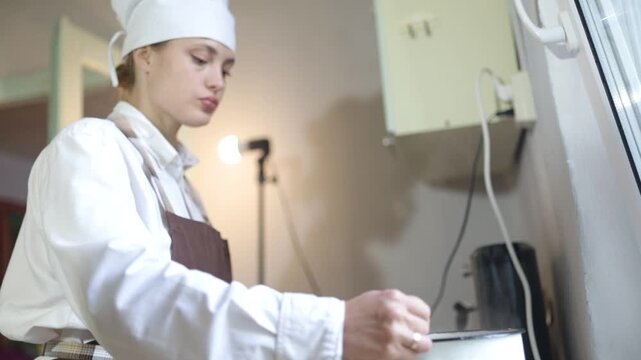 young female cook cooking in the kitchen at home