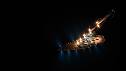 Aerial drone night shot of illuminated sail boat with wooden deck anchored in deep blue Aegan sea © aerial-drone