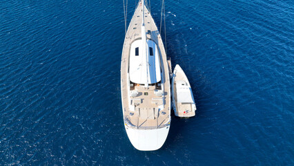Aerial drone photo of beautiful luxury sail boat with wooden deck anchored in deep blue Mediterranean sea  © aerial-drone