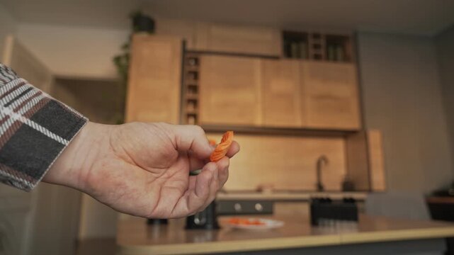 Carrots after vegetable slicing. The hand holds a slice of carrot