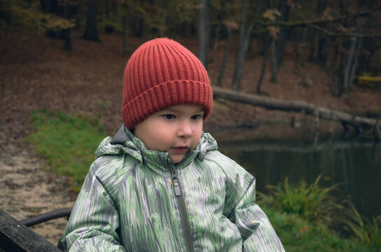 Portrait of child in red hat in autumn park, natural light and childhood lifestyle concept