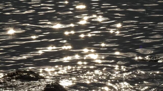 Footage of sea sparkles appearing on the sea surface with sunlight.