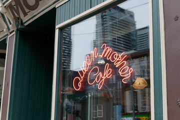 Obraz premium neon sign inside display window of Queen Mother Cafe, a restaurant, located at 208 Queen St W, Toronto