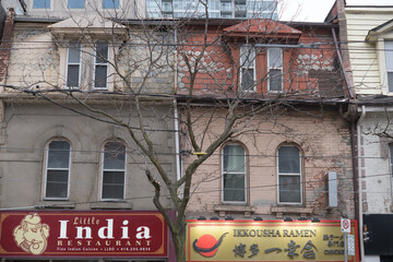 Naklejka premium exterior building facade and sign of Little India Restaurant and Ikkousha Ramen on Queen St W, Toronto