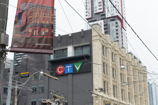 pole mounted banner for Queen Street West with defocused view of CTV and Bell Media building at 299 Queen W, Toronto