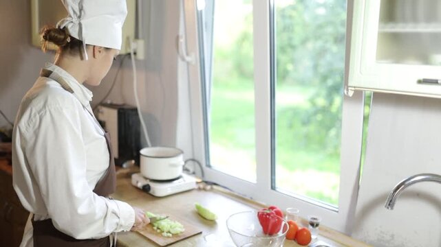 A female cook chopping vegetables in the kitchen