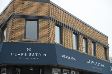 Fototapeta premium exterior building and sign of Heaps Estrin Real Estate Team, a real estate agency, located at 1391 Bayview Av, East York, Toronto