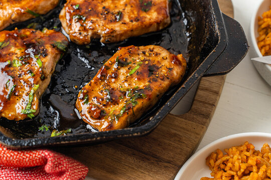 Honey bbq pork chops cooked in a cast-iron skillet. Meat dinner