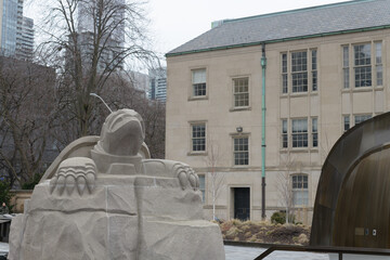 Fototapeta premium six-foot limestone turtle by Solomon King anchors the Spirit Garden, symbolizing Turtle Island and residential school remembrance; it sits in a reflecting pool aligned to Magnetic North, Toronto