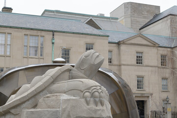 Fototapeta premium six-foot limestone turtle by Solomon King anchors the Spirit Garden, symbolizing Turtle Island and residential school remembrance; it sits in a reflecting pool aligned to Magnetic North, Toronto