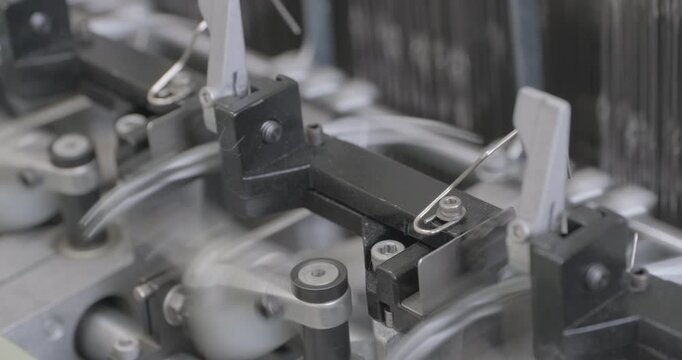 Spinning equipment, weaving machine, the jacquard loom is working. The parts of the mechanism move rhythmically, performing reciprocating movements. Close-up handheld shot, real time speed.