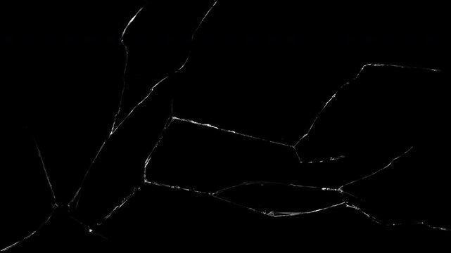 Large expanding glass crack spreading across surface with realistic fracture patterns and sharp shards, captured as a high-contrast overlay for impact VFX