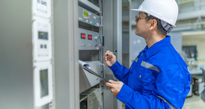 Electrical engineer woman checking voltage at the Power Distribution Cabinet in the control room,preventive maintenance Yearly,Thailand Electrician working at company