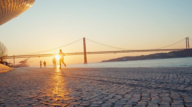 Man jogging along lisbon riverfront at sunrise