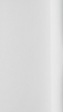 Extreme close-up, top-down of delicate pure white matte material with elegant creases unfolding smoothly under soft high-key light. Concept of new beginnings