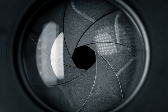 Black camera lens with half closed aperture blades closeup
