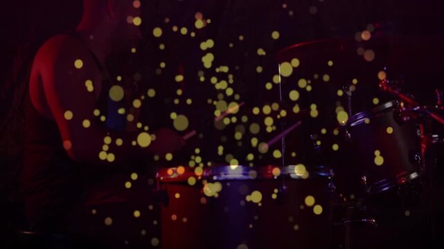 Male drummer playing congas and kit, yellow dots appearing over drum heads and shifting for music