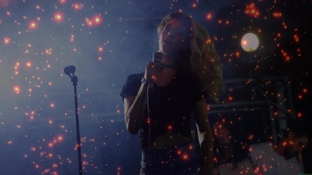 Lead singer whipping hair at music concert, sparking ember overlay, band playing, singing into mic