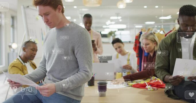 Design team gathering at table, man reading sheets, phone tapping animating metrics guiding review
