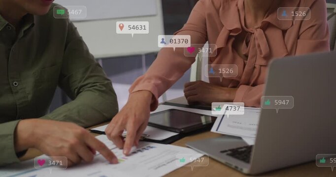Vertical video: Metrics rising causing bow blouse woman and man checking tablet at meeting table