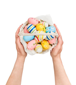 Man hand holding basket filled with painted Easter eggs isolated on white background with clipping path, designe element, symbolizing Easter celebrations. Easter greeting card.