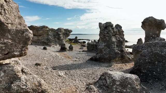 Drone flying at low altitude between limestone sea stacks in raukf&auml;lt at Folhammar on Gotland, Sweden with coastal rocks and Baltic Sea in view