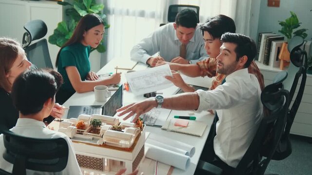 Top down view of skilled engineer team compare between blueprint and house plan. Aerial view of group of architect or designer discussing and point note to brainstorm about blueprint. Alimentation.