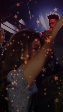 Vertical video: Singer starting song, woman raising arms and dancing to music under star overlay