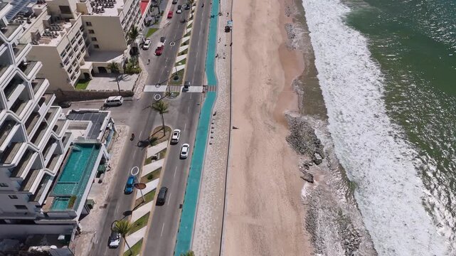 Vista aerea del malecon de Mazatlan Mexico, el vieo muestra un paisaje urbano con hoteles frente al mar y carros circulando tranquilamente.