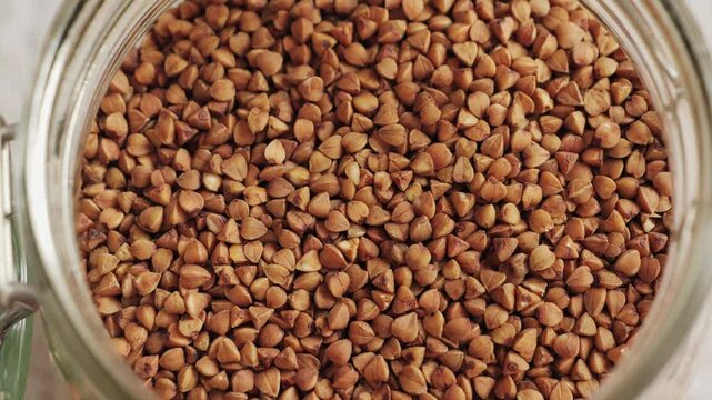 Close up of buckwheat grains texture. Detailed view of dry buckwheat, natural food background and healthy ingredient concept. High quality 4k footage