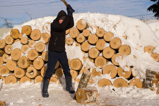 A teenage boy learns to chop wood