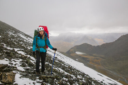 Young woman climber against the backdrop of beautiful mountains.